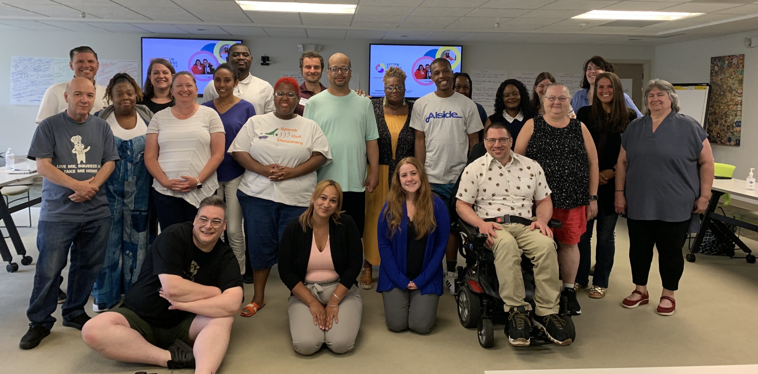 A group of people inclusive of people with disabilities pose for a group photo.